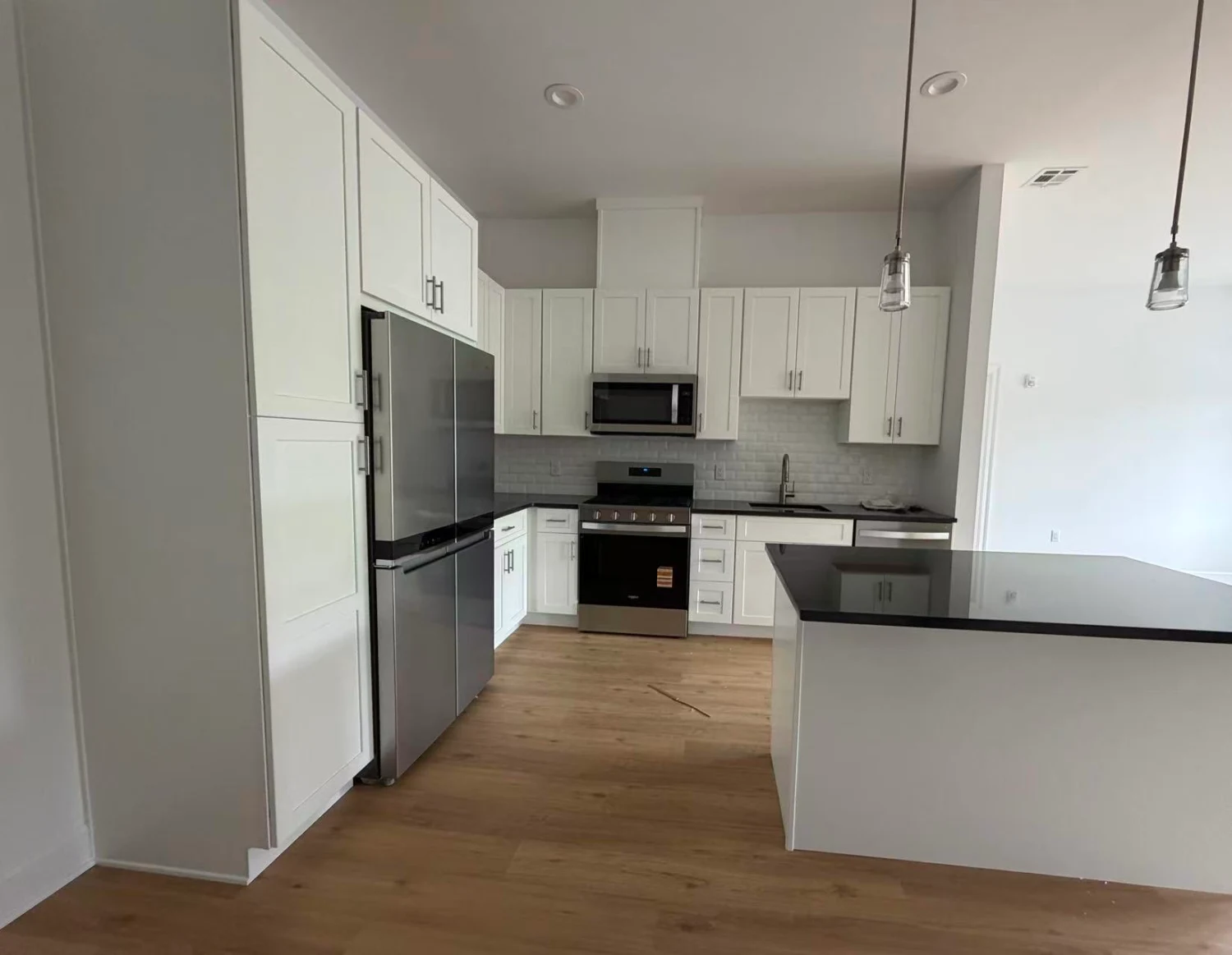 Kitchen with island, pendant lighting and stainless appliances