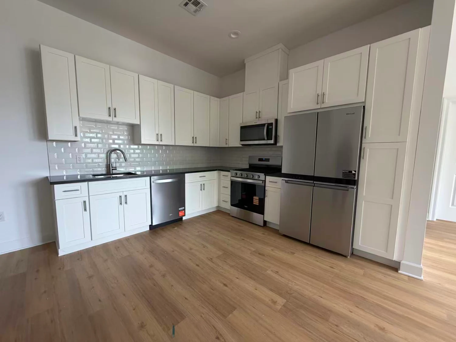 Kitchen with stainless appliances, quartz counters and subway tile backsplash
